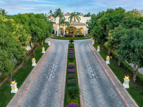 Tree-lined driveway with lanterns and gardens leading to Casa Velas.
