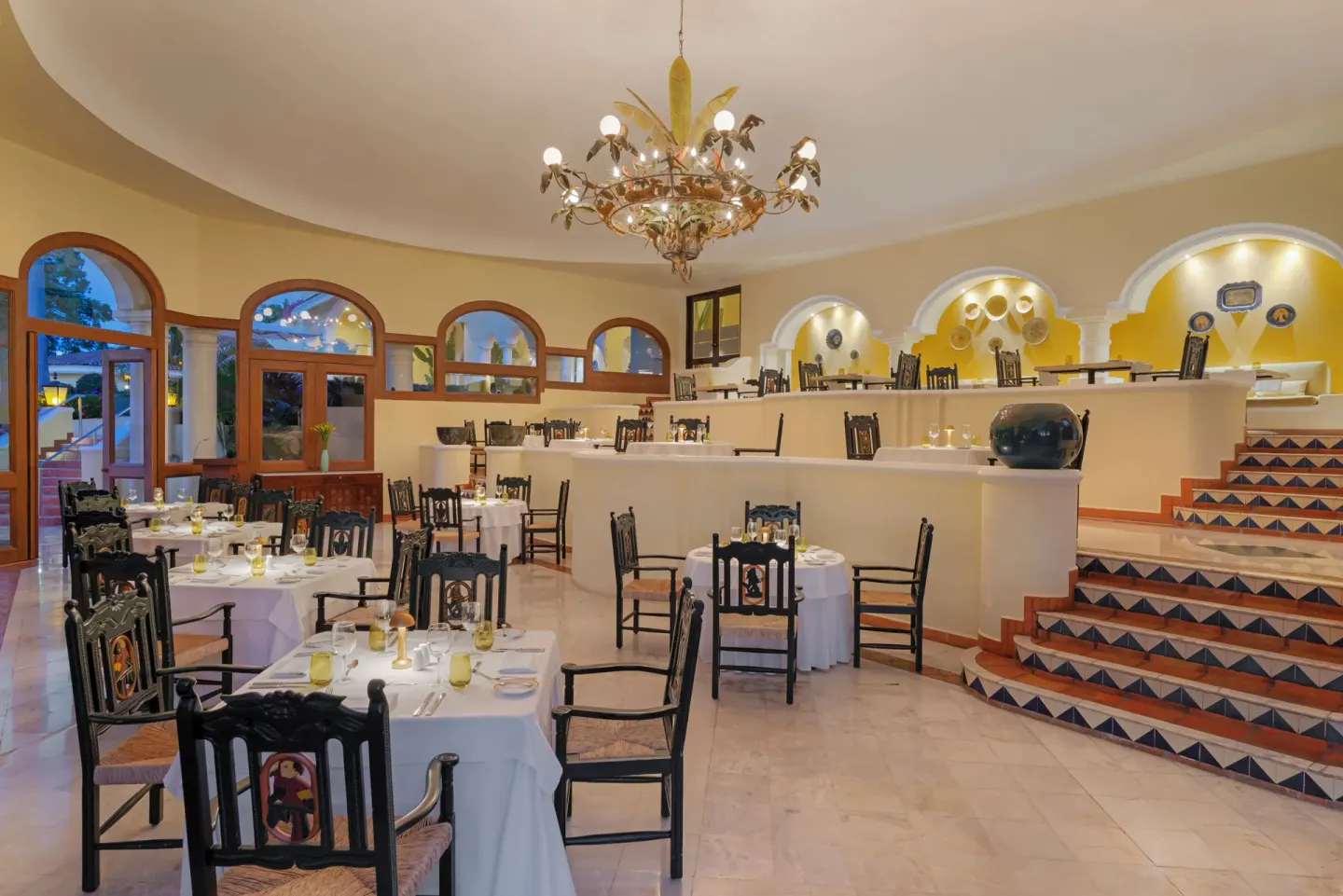 Tiered dining room with tiled stairs and set tables at Casa Velas.