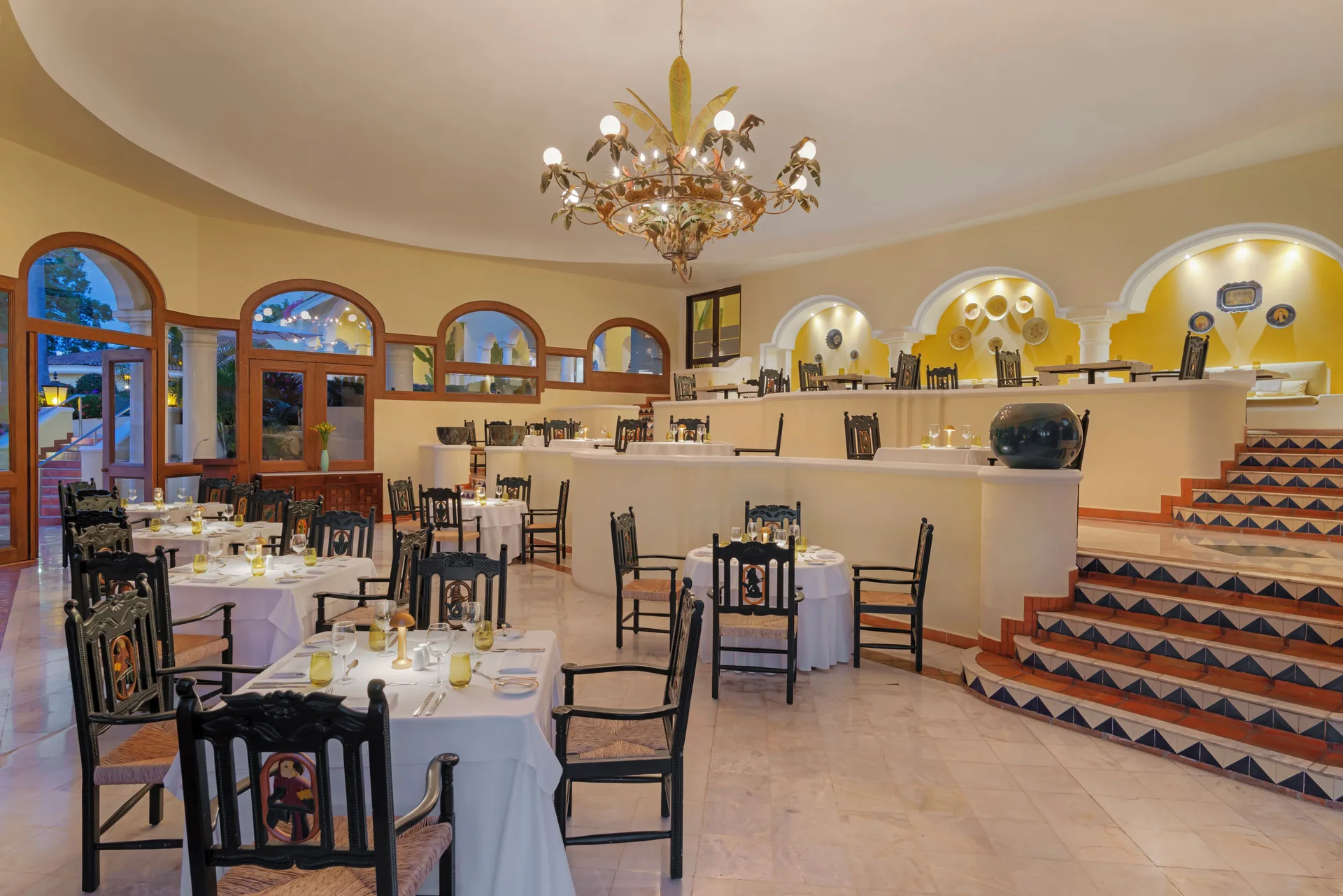 Tiered dining room with tiled stairs and set tables at Casa Velas.