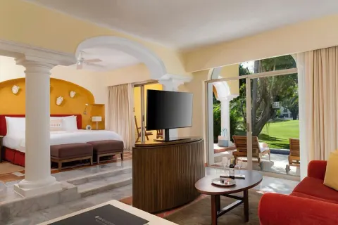Grand Class Plus king bed suite with sitting area and terrace view at Casa Velas.