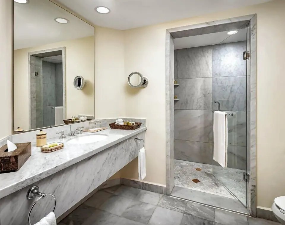 Grand Class Suite bathroom with marble vanity and glass shower at Casa Velas.
