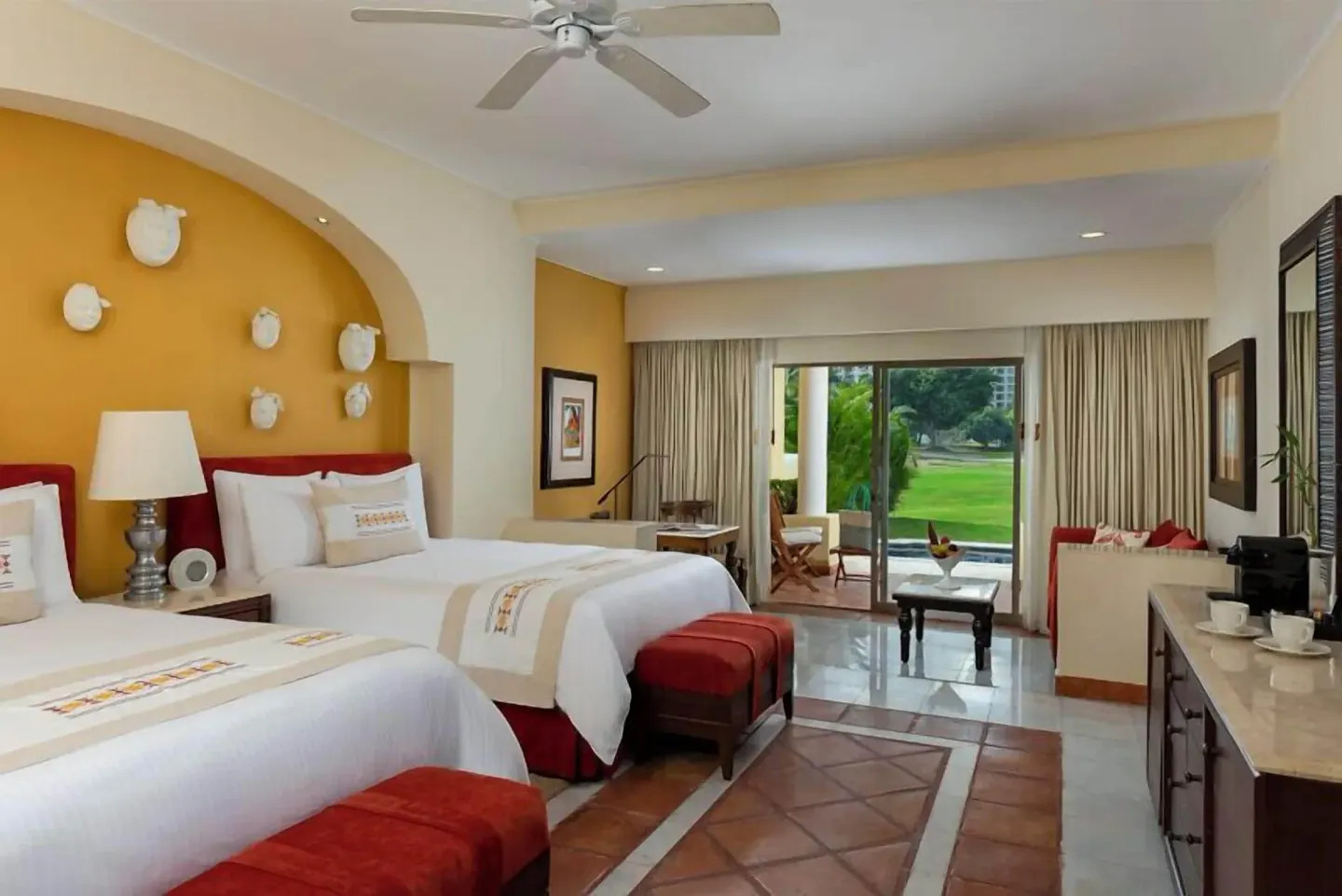 Grand Class Suite with two beds, patio doors, and garden view at Casa Velas.