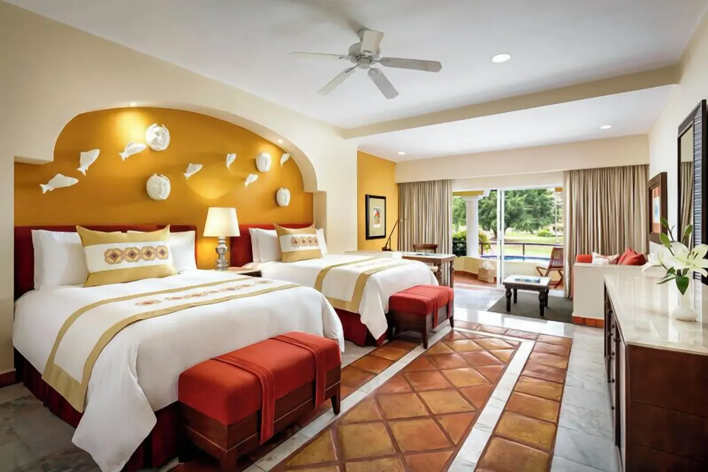 Grand Class Suite with two beds, red benches, and bright patio view at Casa Velas.