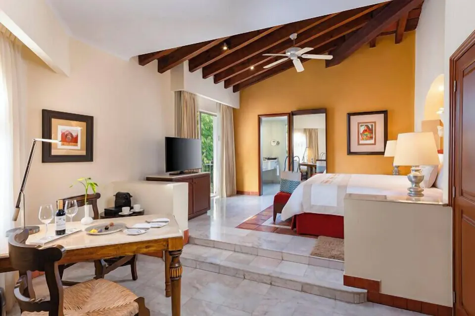 Master Suite Plus with raised king bed area and dining table at Casa Velas.