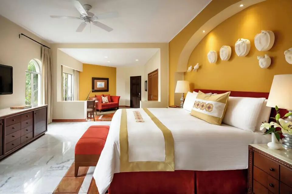 Master Suite Plus king bed with sitting area and arched windows at Casa Velas.