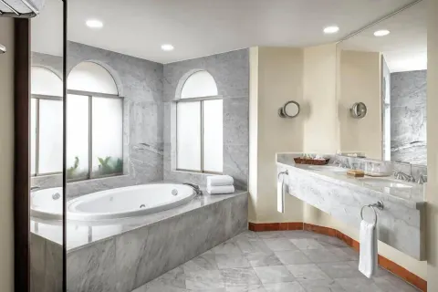 Master Suite Plus marble bathroom with oval tub and double vanity at Casa Velas.