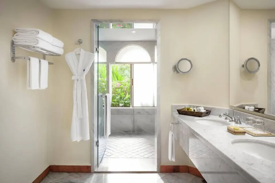 Master Suite bathroom at Casa Velas with marble vanity, robes, towels, and glass shower entrance.