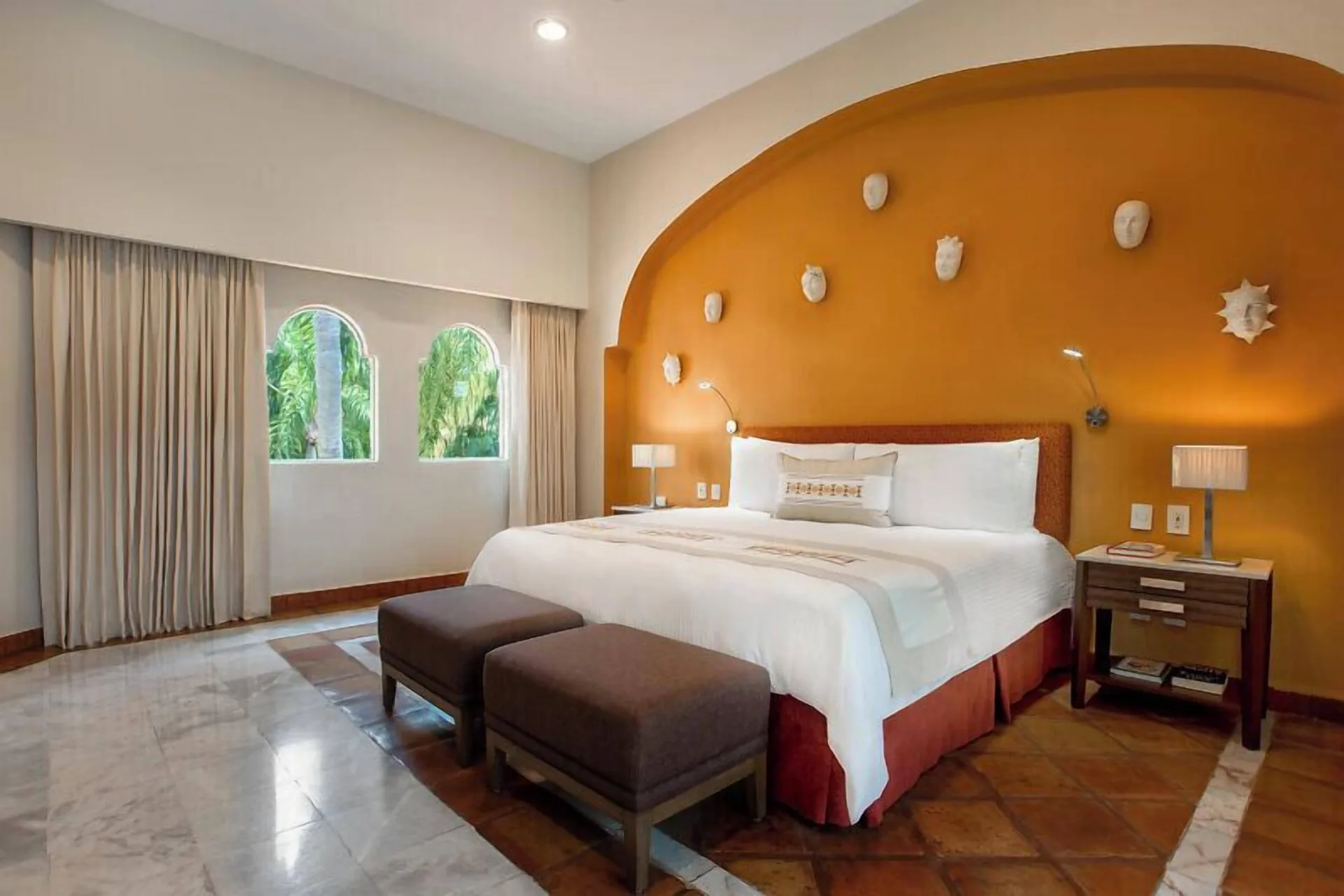 One Bedroom Ambassador Suite king bed with orange arched headwall at Casa Velas.
