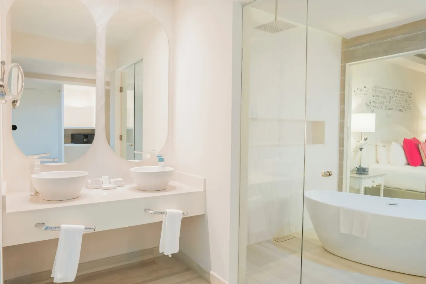Bright bathroom with twin sinks, glass shower, and freestanding tub at Catalonia Playa Maroma.