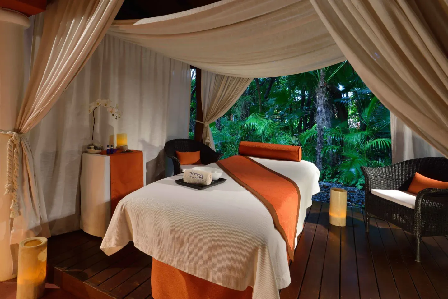 Canopied spa treatment bed beside tropical greenery at Catalonia Playa Maroma.