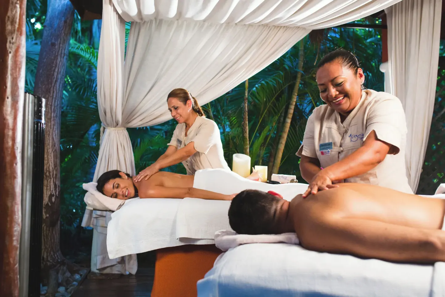 Two guests receiving massages in a draped spa pavilion at Catalonia Playa Maroma.