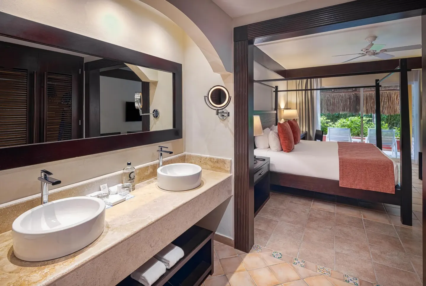 Guest room vanity and canopy bed with terrace at Catalonia Playa Maroma.