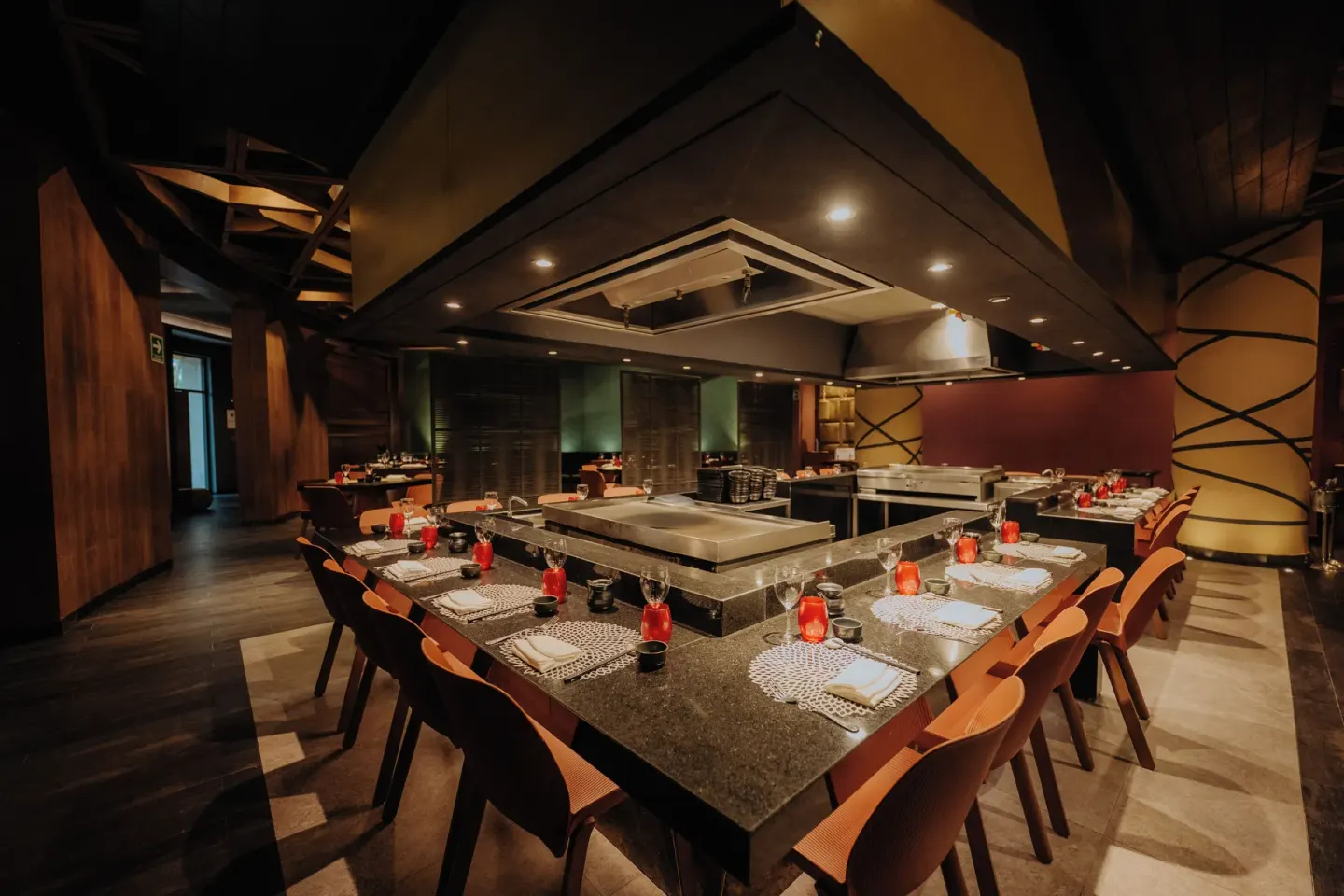 Teppanyaki-style dining counter set with plates and red candles at Catalonia Playa Maroma.