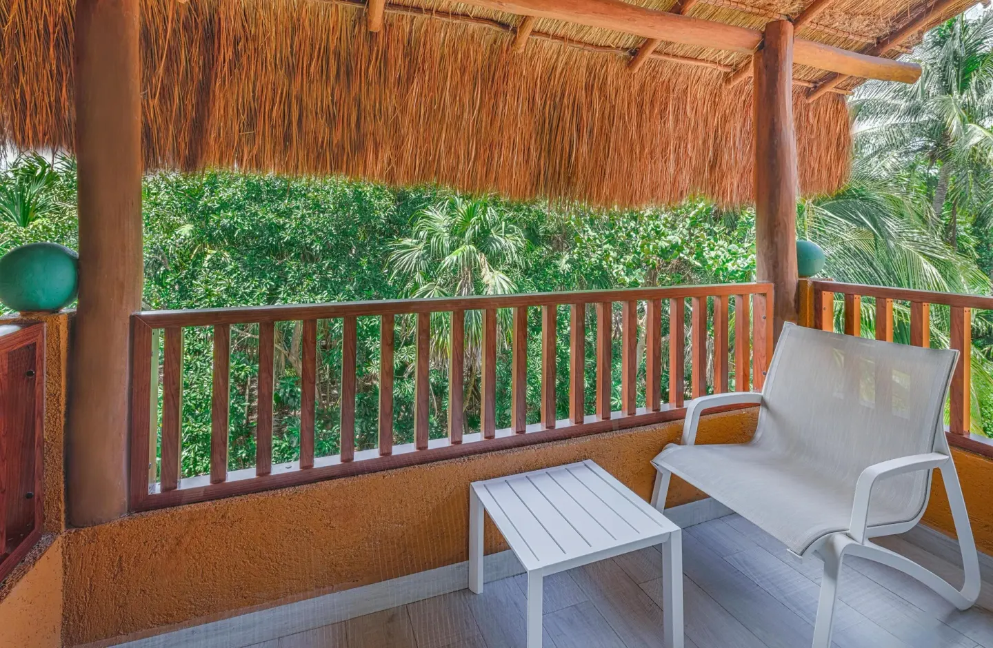 Premium Deluxe Room balcony with seating and garden greenery at Catalonia Playa Maroma.