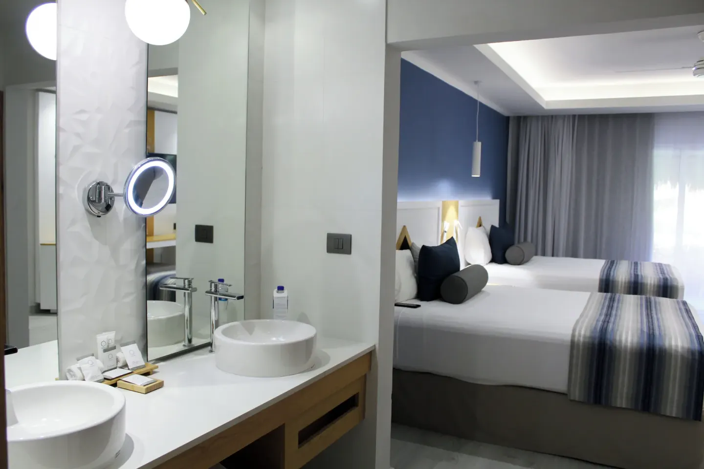 Premium Deluxe Room vanity opening to two beds at Catalonia Playa Maroma.