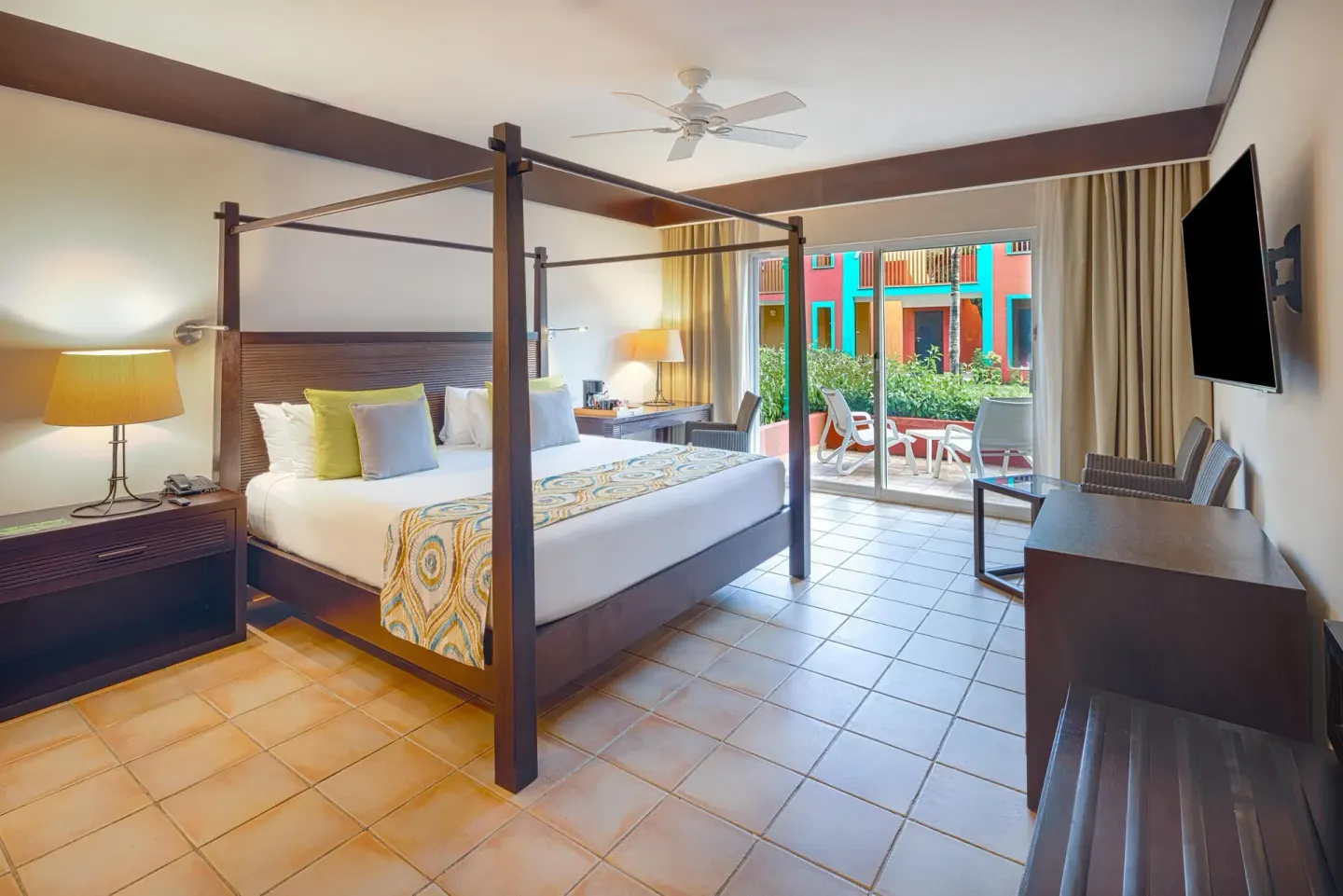 Premium Room king bed with terrace doors and wall-mounted TV at Catalonia Playa Maroma.