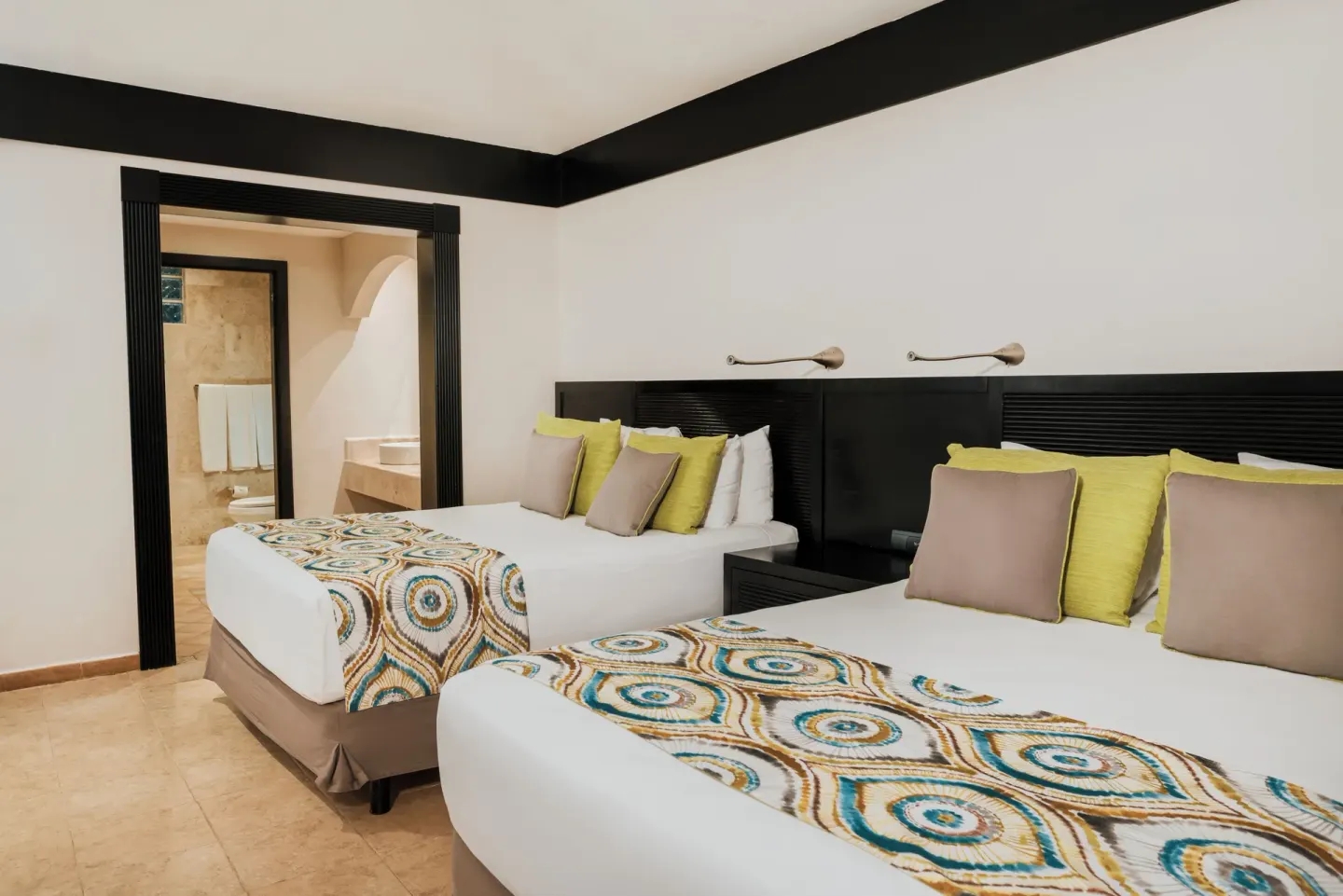 Premium Room with two beds and an open bathroom doorway at Catalonia Playa Maroma.