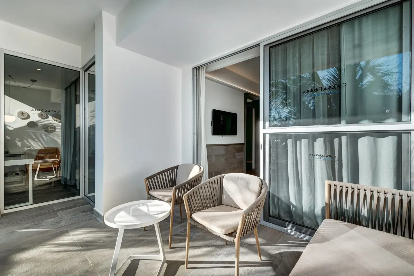 Privileged Suite covered terrace with chairs and sliding doors at Catalonia Playa Maroma.