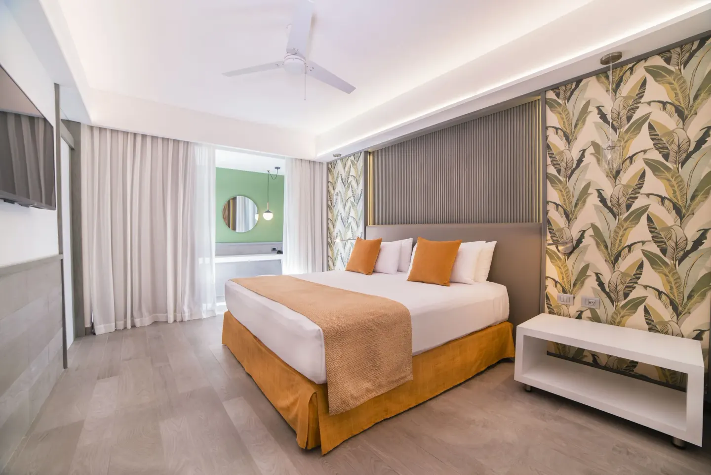Privileged Suite bedroom with king bed and leafy wallpaper at Catalonia Playa Maroma.