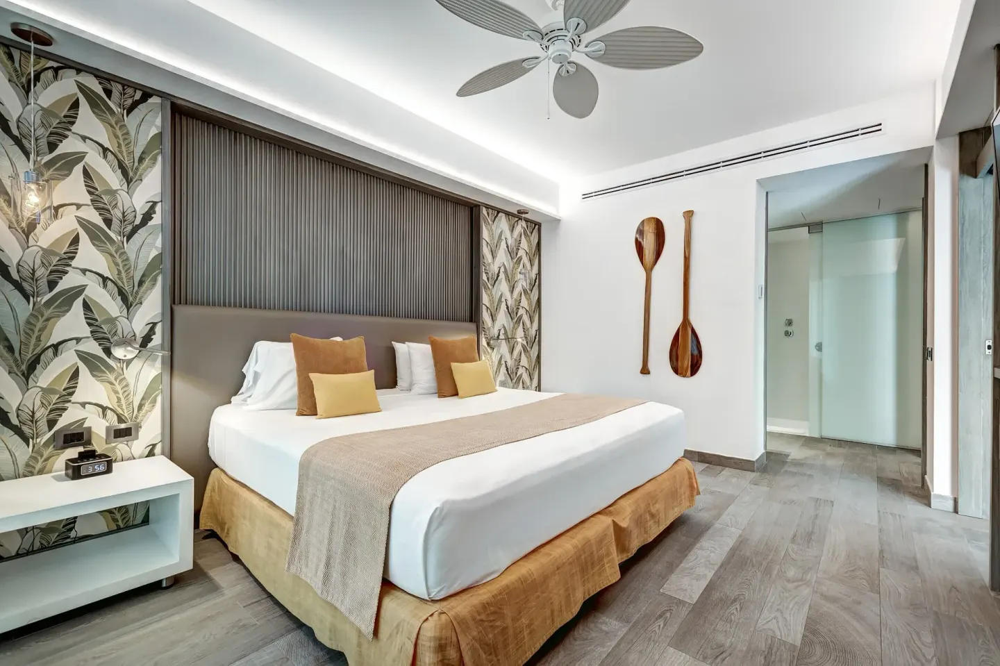 Privileged Suite king bed with tropical wallpaper and paddle wall art at Catalonia Playa Maroma.