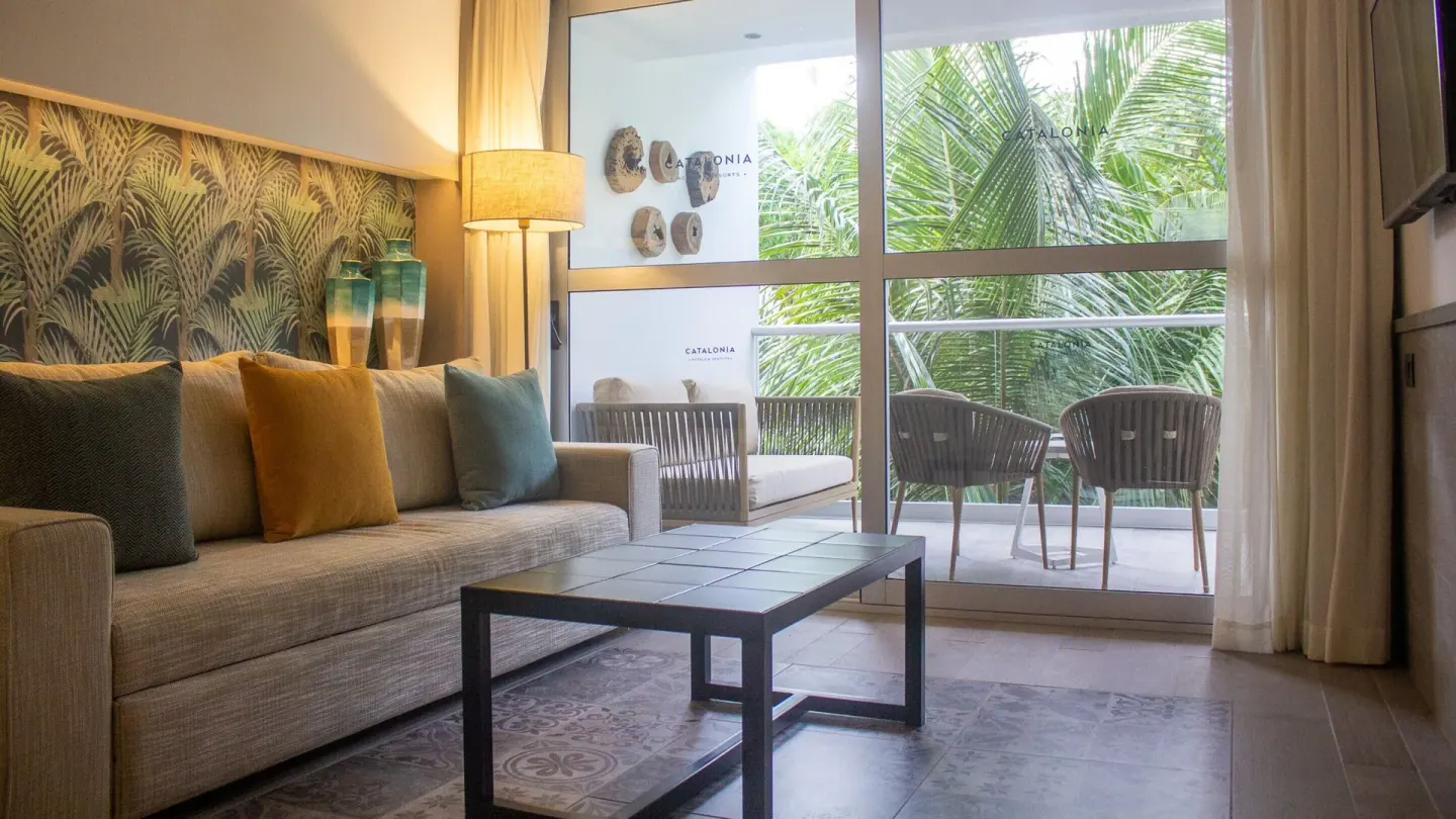 Privileged Suite lounge opening to a furnished balcony at Catalonia Playa Maroma.