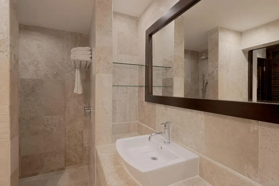 Compact bathroom sink and walk-in shower in a guest room at Catalonia Riviera Maya Resort and Spa
