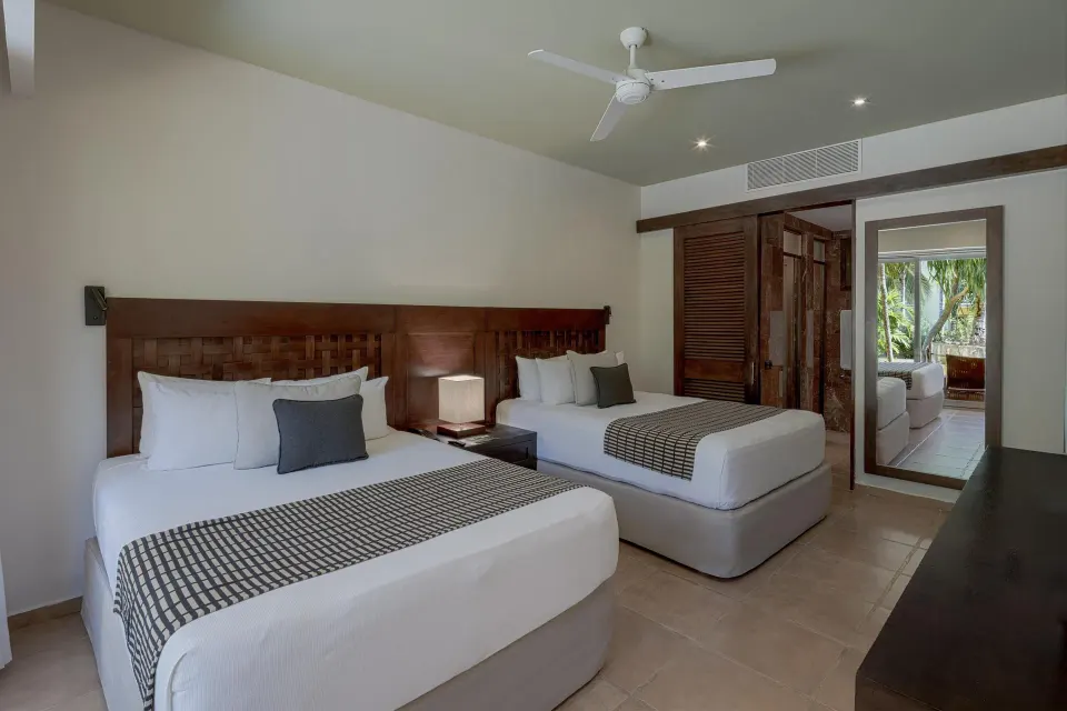 Twin-bed room with wooden headboards and tiled floor at Catalonia Riviera Maya Resort and Spa