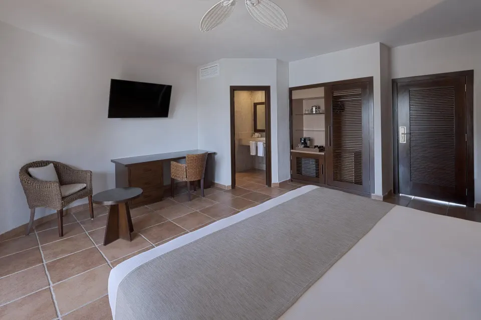 View from bed toward desk, TV, and bathroom entrance in king suite at Catalonia Riviera Maya Resort and Spa