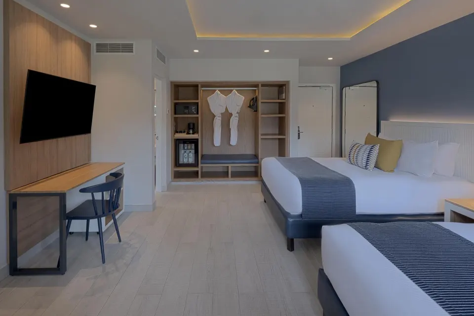 Large guest room with king bed, TV and open wardrobe at Catalonia Riviera Maya Resort and Spa