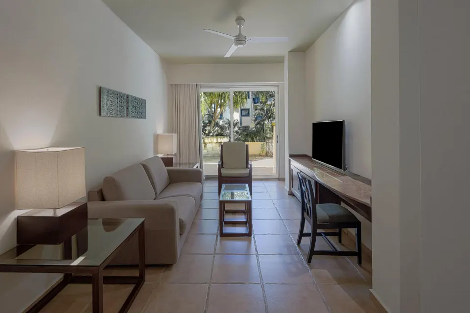 Living area and balcony of a guest suite at Catalonia Riviera Maya Resort and Spa