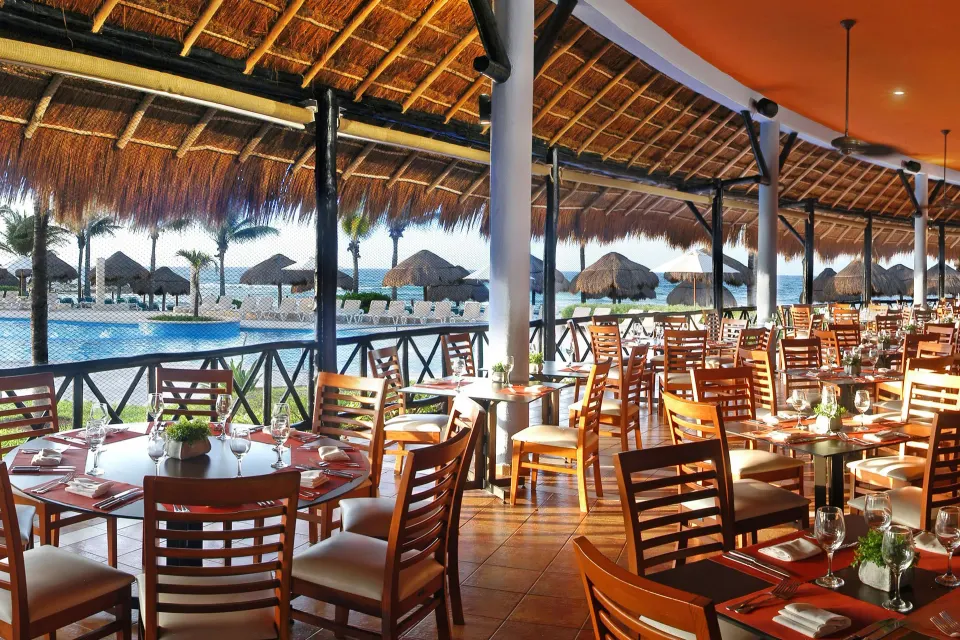 Open-air dining area overlooking the pool and sea at Catalonia Riviera Maya Resort and Spa