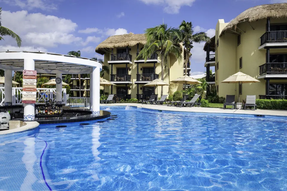 Pool with swim-up platform and resort balconies at Catalonia Riviera Maya Resort and Spa