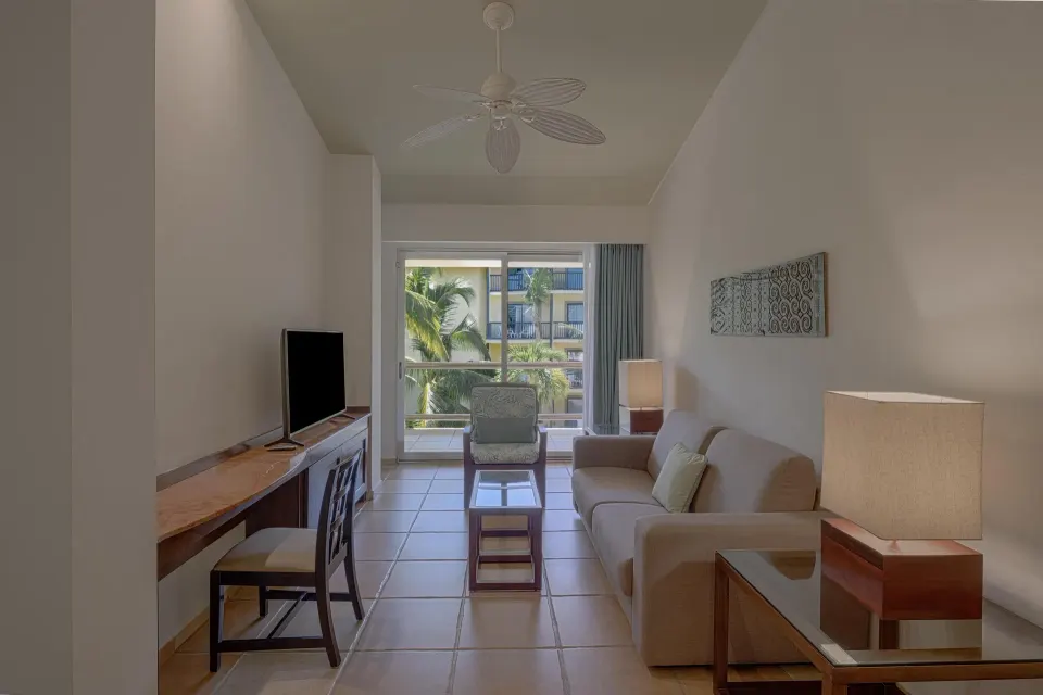 Sofa and desk area in a guest suite at Catalonia Riviera Maya Resort and Spa