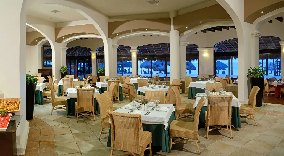 Open-air dining room with arched columns and table settings at Catalonia Riviera Maya Resort and Spa