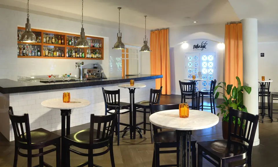 Intimate indoor bar with high tables and stools at Catalonia Riviera Maya Resort and Spa