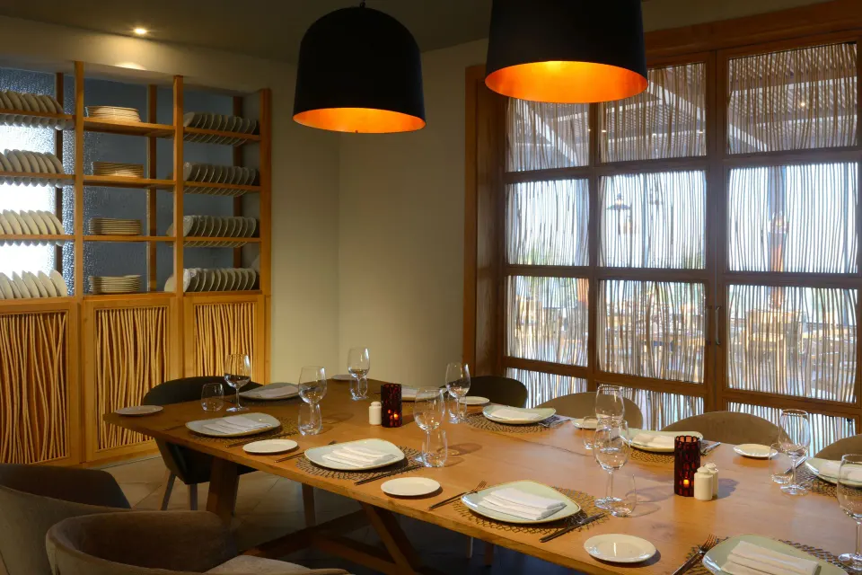 Private dining table with place settings and soft pendant lights at Catalonia Riviera Maya Resort and Spa