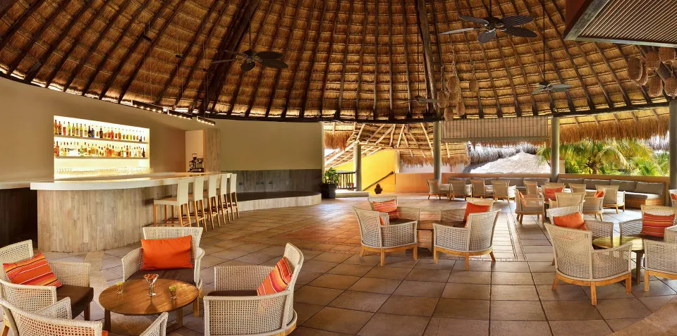 Palapa-roofed lounge bar with wicker seating at Catalonia Riviera Maya Resort and Spa