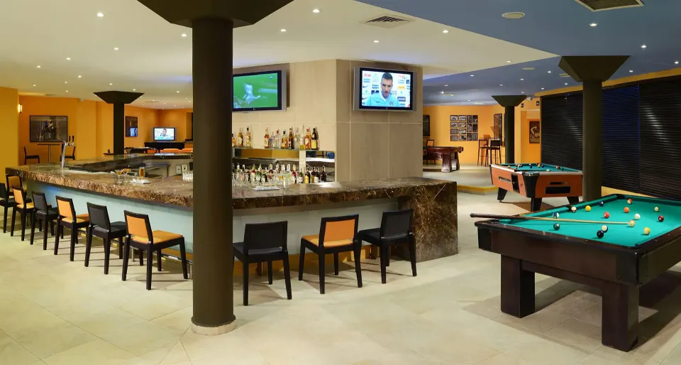 Interior of the sports bar with marble counter, TVs and pool tables at Catalonia Riviera Maya Resort and Spa