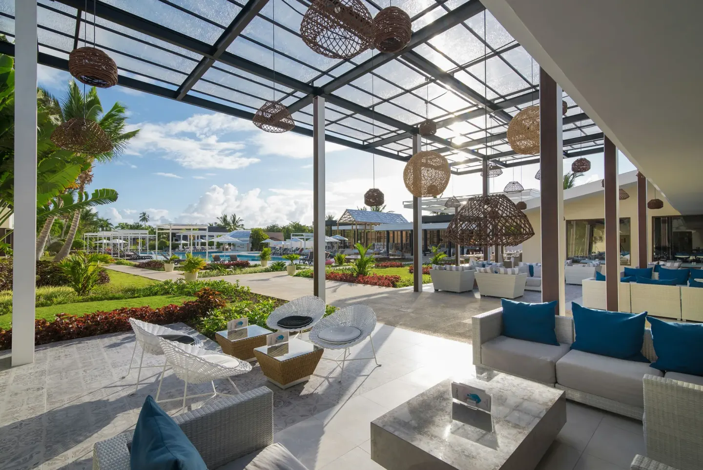 Covered lounge terrace with wicker lights and pool views at Catalonia Royal Bavaro.