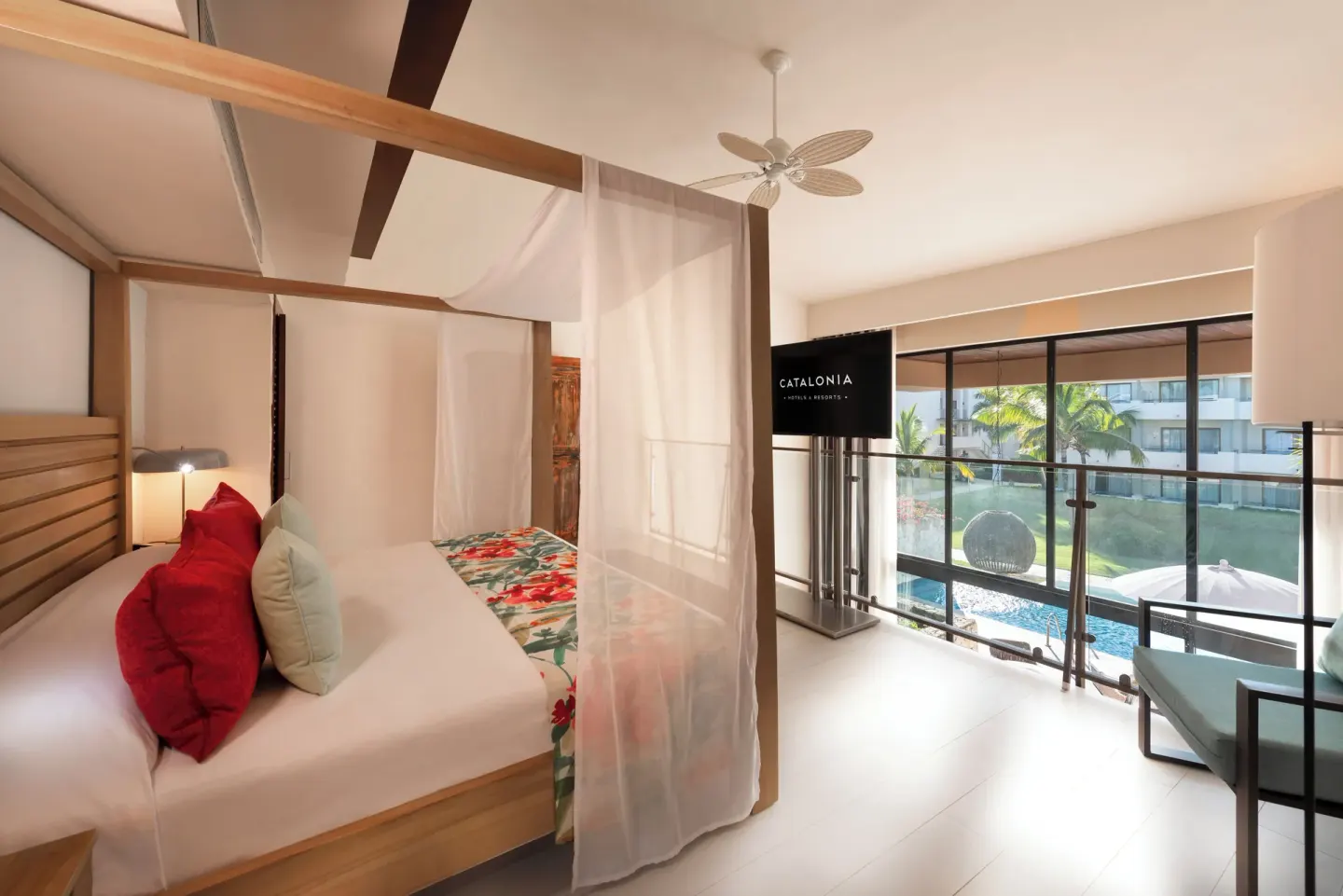 Guest room with canopy king bed and balcony view at Catalonia Royal Bavaro.