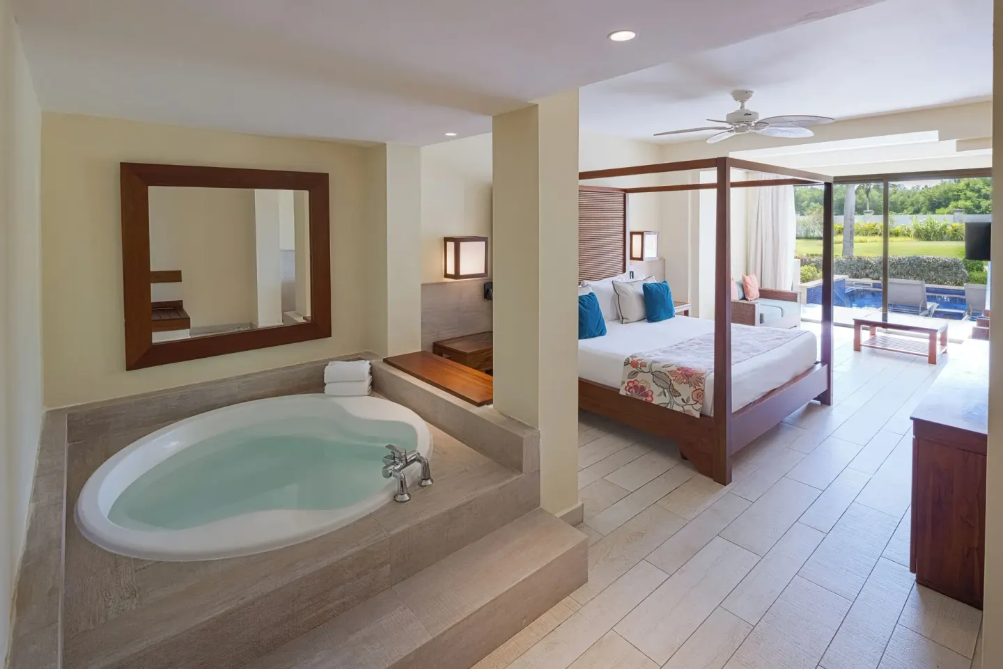 Guest room with four-poster king bed and soaking tub at Catalonia Royal Bavaro.