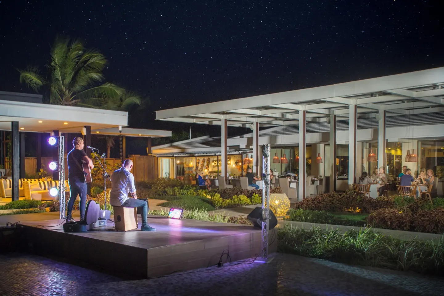 Live musicians perform on an outdoor stage at Catalonia Royal Bavaro under a starry night sky.