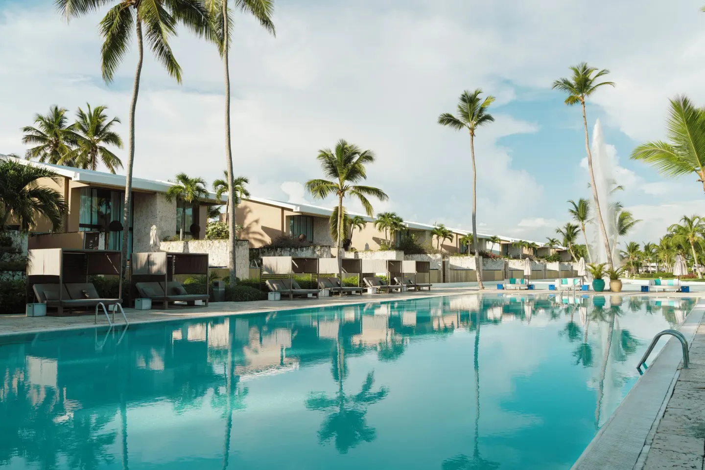 Long pool lined with cabanas and palm trees at Catalonia Royal Bavaro.