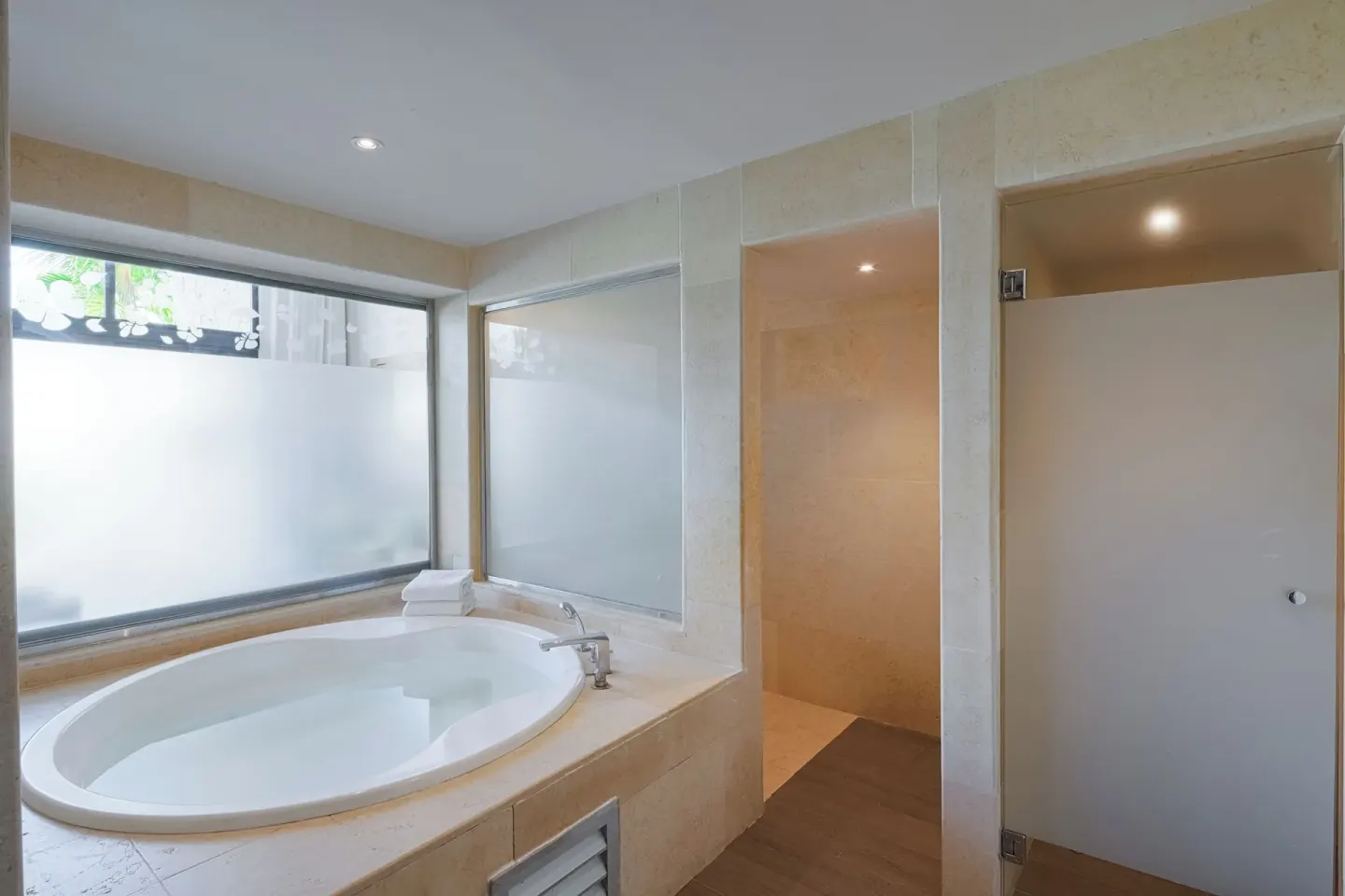 Bathroom soaking tub beside frosted windows at Catalonia Royal Bavaro.
