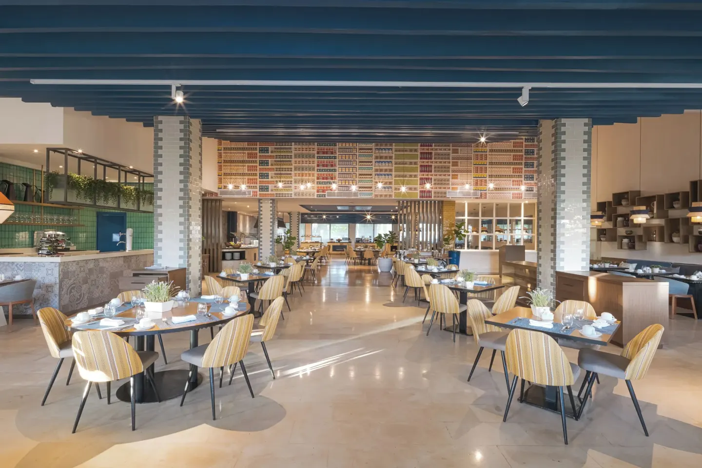 A bright buffet-style restaurant dining room is set with round tables at Catalonia Royal Bavaro.