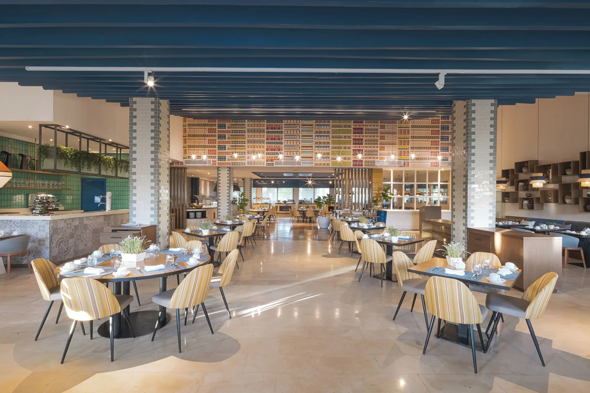 A bright buffet-style restaurant dining room is set with round tables at Catalonia Royal Bavaro.