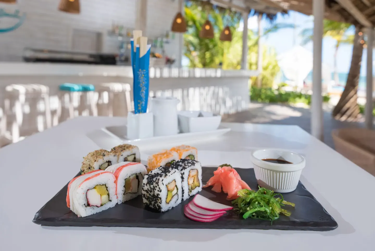 Sushi rolls served on a black plate at an open-air bar at Catalonia Royal Bavaro.