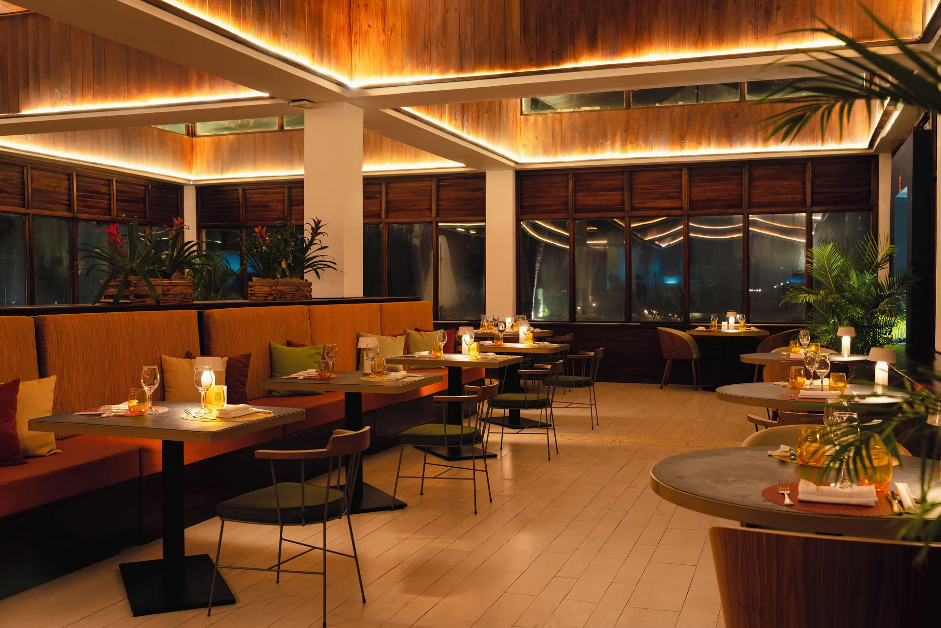 A warmly lit restaurant dining room with set tables at Catalonia Royal Bavaro.