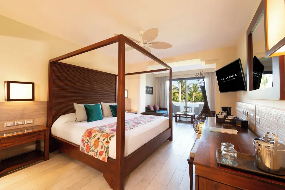 Premium Junior Suite king bed, desk, and balcony view at Catalonia Royal Bavaro.