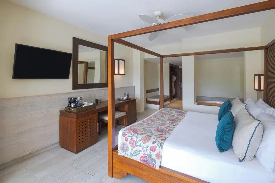 Privileged Deluxe Junior Suite bedroom with canopy bed and desk at Catalonia Royal Bavaro.